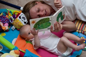 Mother reading a book to little caucasian girl.